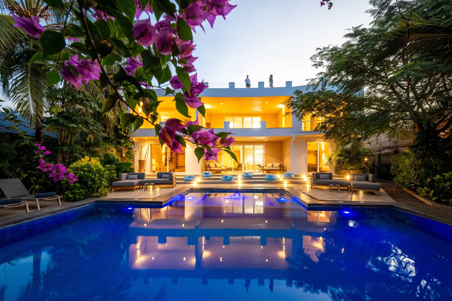 Villa Kokos lit up at dusk, reflections on the pool