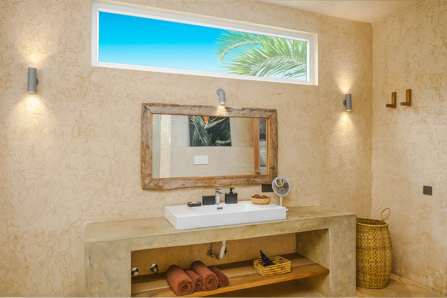 Bathroom with tropical shower and natural stone finishes