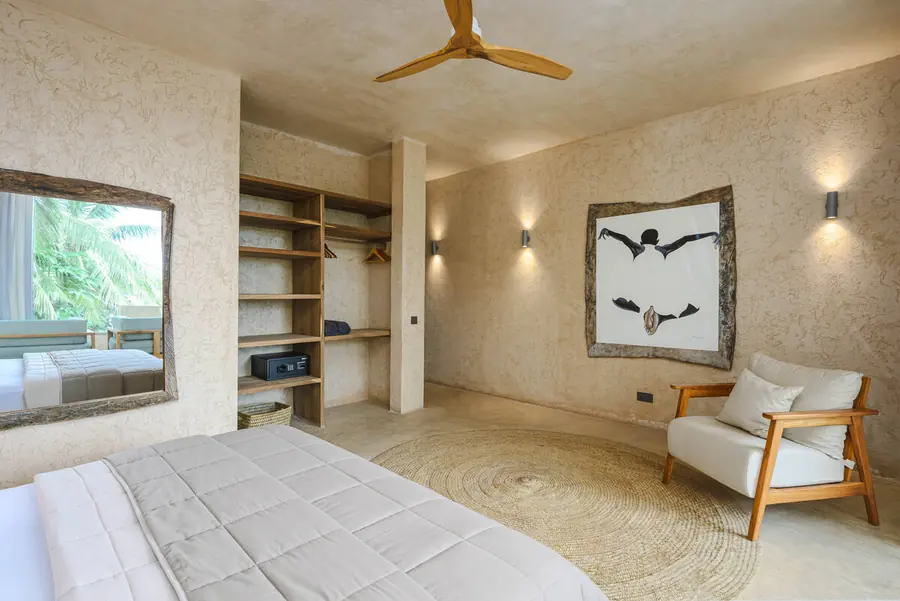 Suite with open wardrobe and reading chair at Villa Kokos